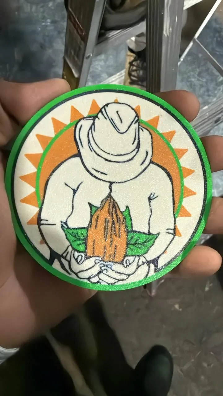 Soporte de vaso circular impreso en 3D con el diseño de Babahoyo Export, sostenido en la mano